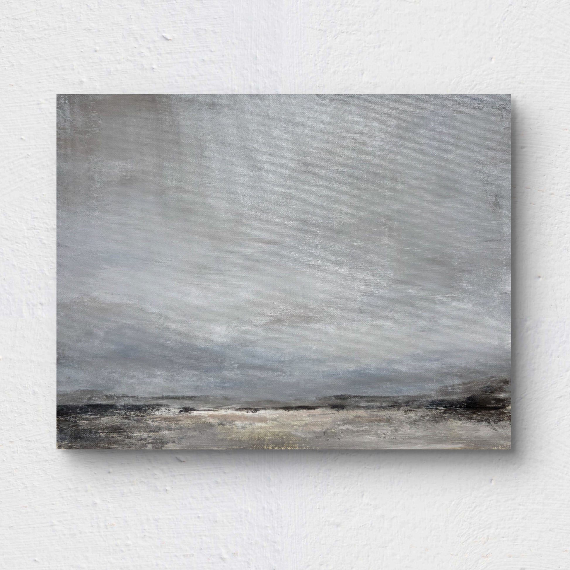 Abstract landscape painting with gray and brown tones on a textured white wall.